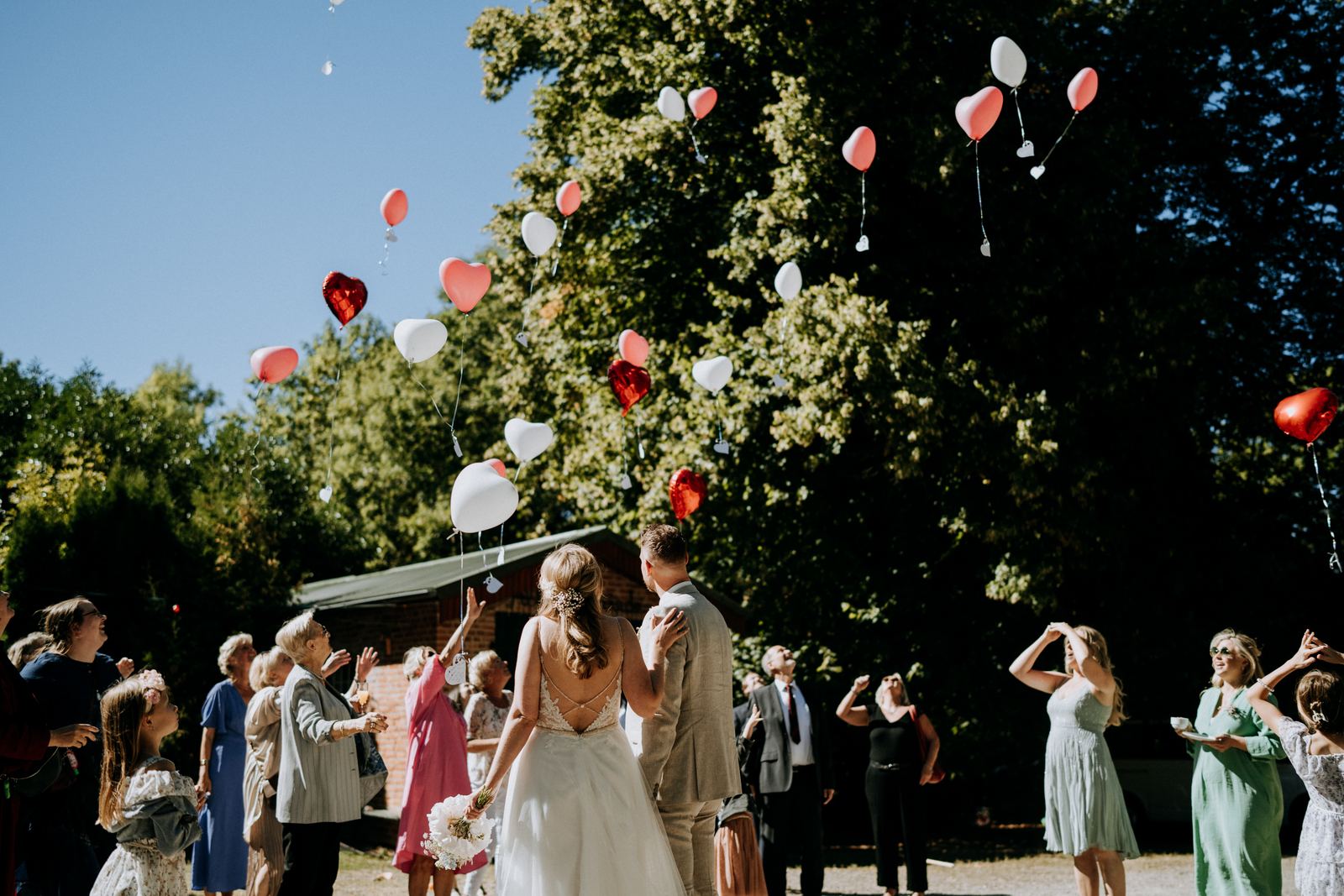 Herzluftballons steigen bei einer Hochzeit am Blossom Beach in den Himmel