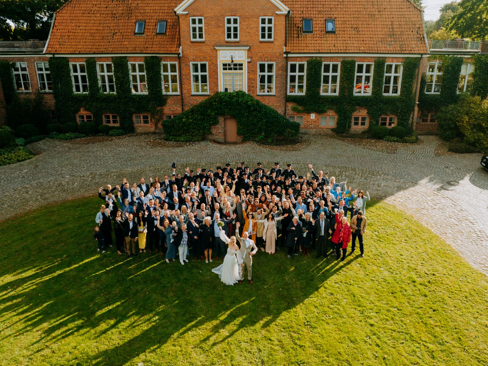 Drohnenfoto der ganzen Hochzeitsgesellschaft vor dem Herrenhaus von Gut Marutendorf
