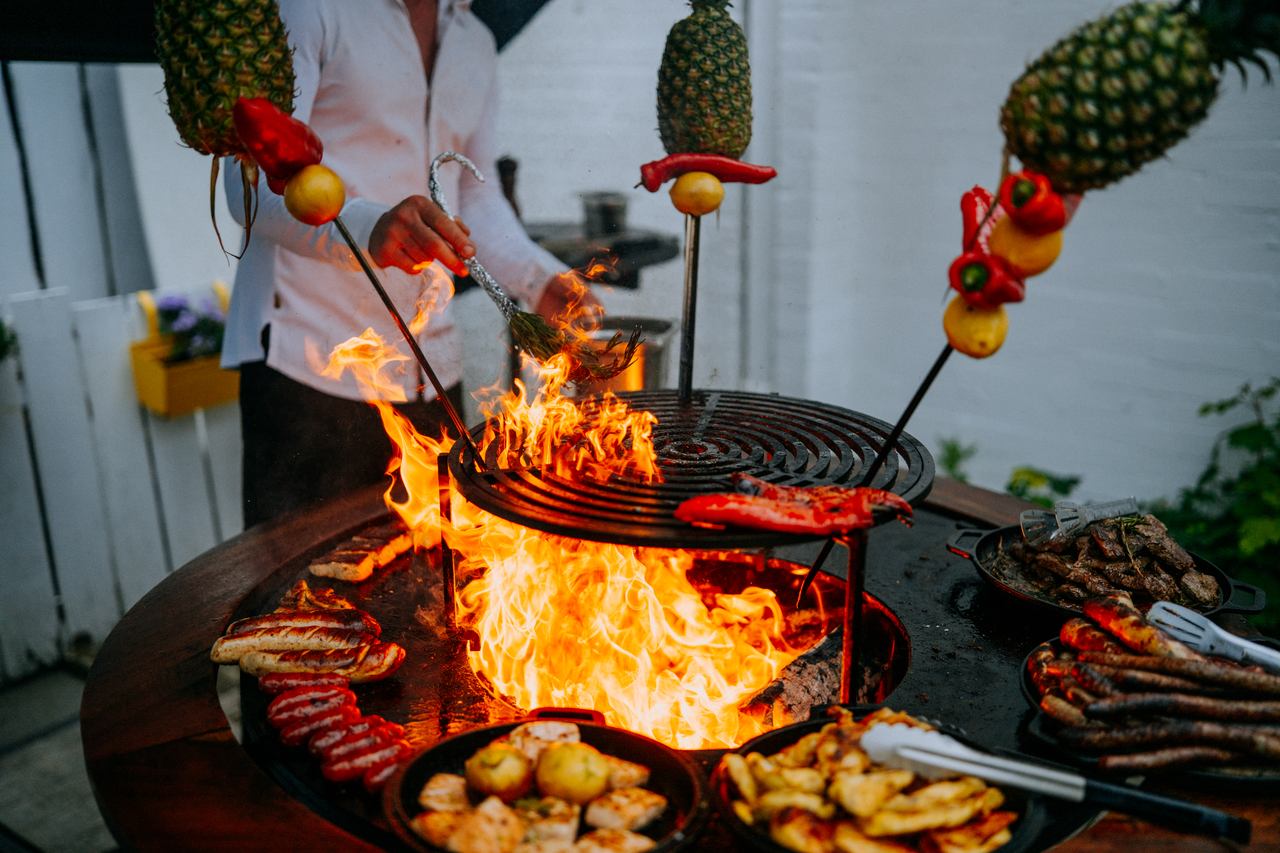 Spieße mit Ananas und Paprika am offenen Feuergrill bei der Hochzeitsfeier