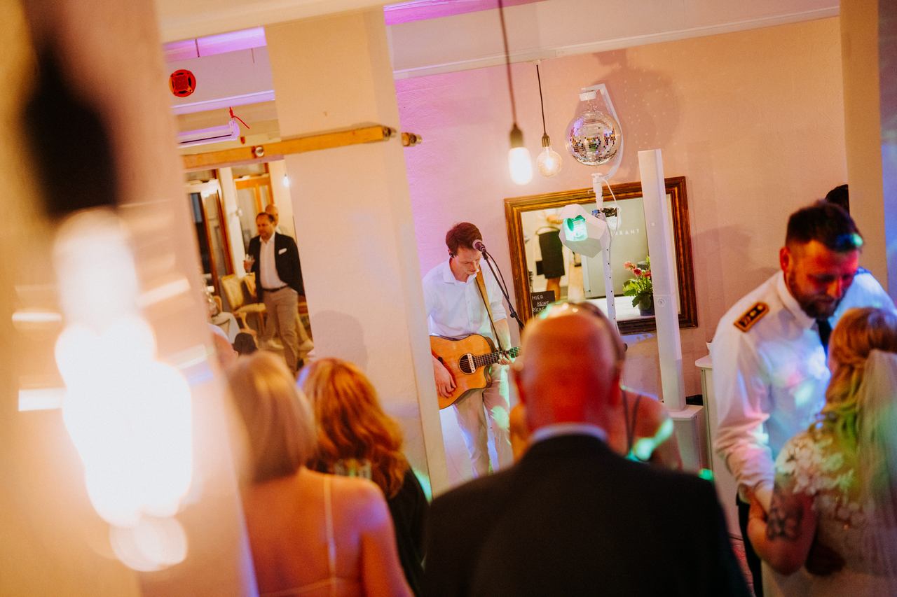 Live-Musiker mit Gitarre unter der Discokugel bei der Hochzeitsparty von Stina und Delf
