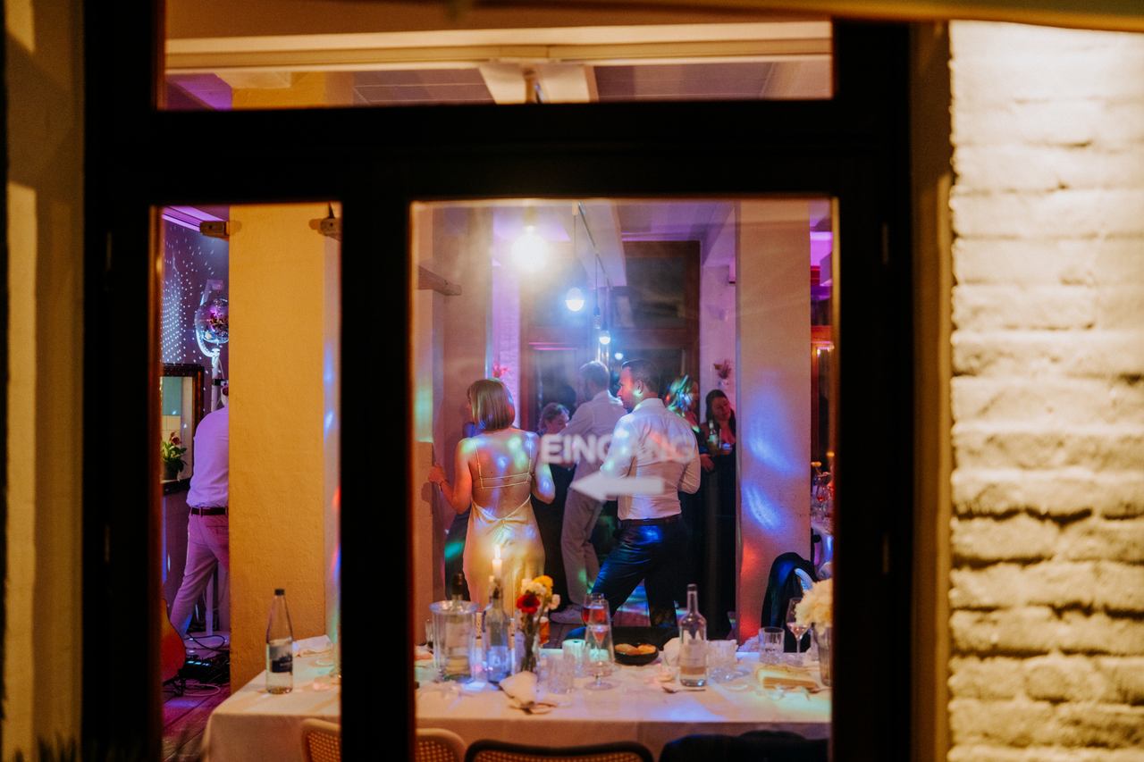Blick durch das Fenster auf die abendliche Tanzfläche bei Ute im Bikini