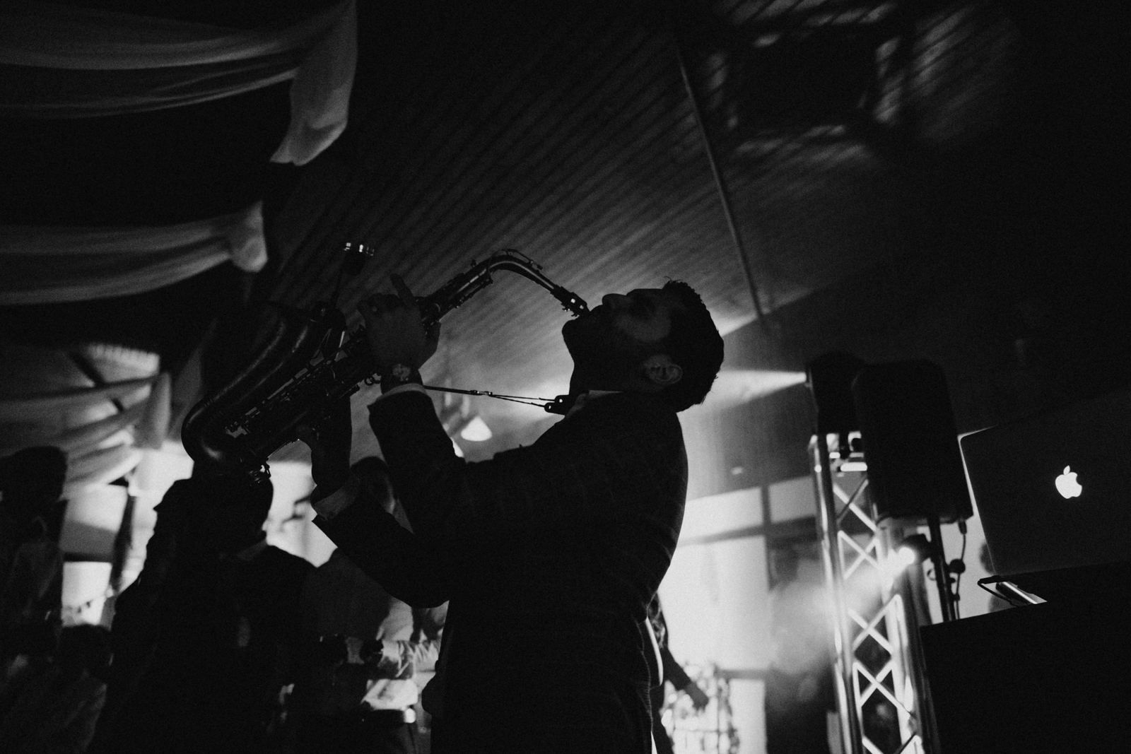 Silhouette eines Saxofonisten auf einer Hochzeitsparty in Schwarzweiß